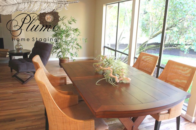 Dining Room table with low back chairs and low centerpiece in Redmond Rambler showcases the prominent wall of windows. Touches of greenery bring the outside in.